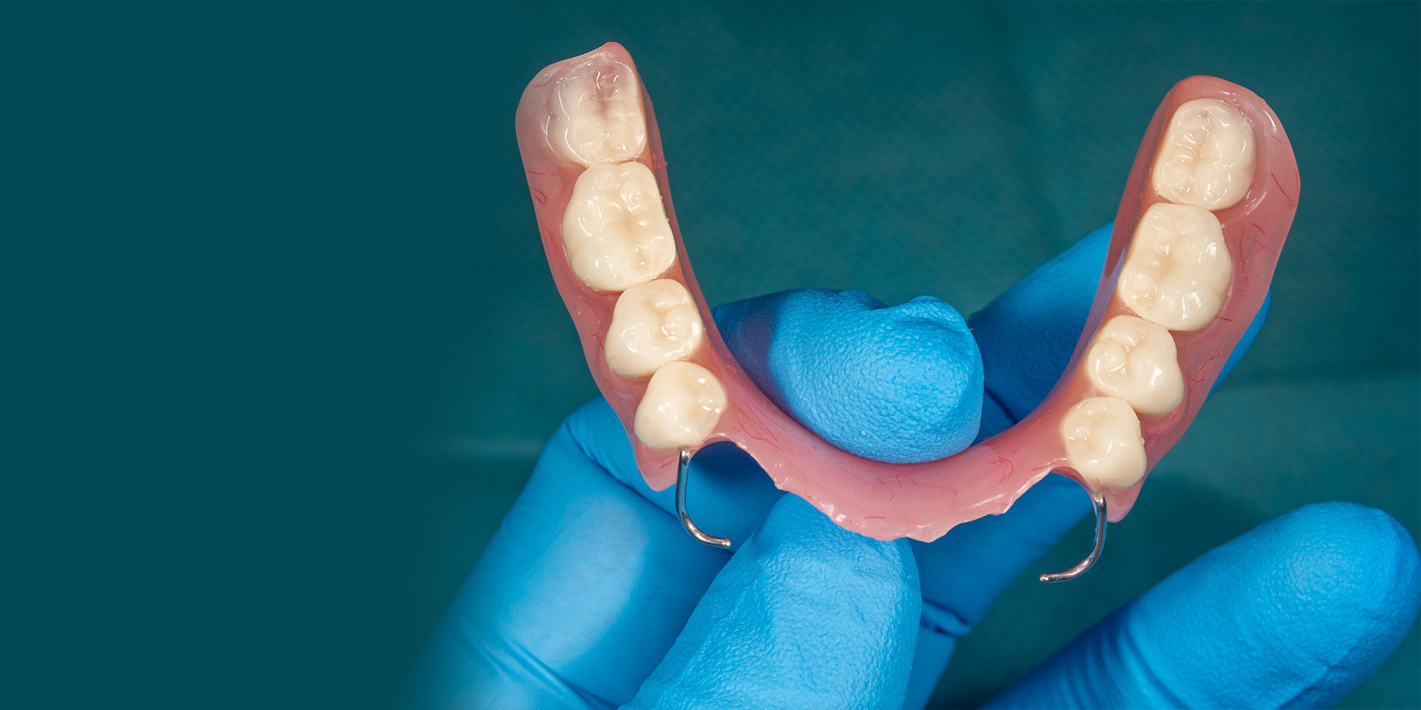 dentist holding up a partial denture